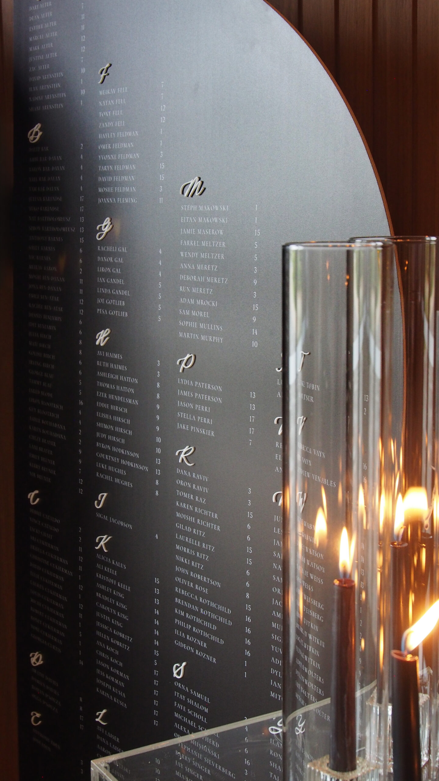 Large arch-shaped wedding seating chart with minimalist guest list layout